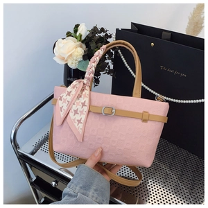 Détail du sac à main rose gaufré avec foulard en soie pied-de-poule et anses en cuir brun
