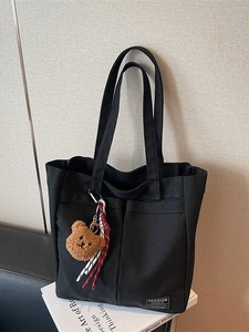 Large black canvas tote bag with twin handles and cute teddy bear pendant charm