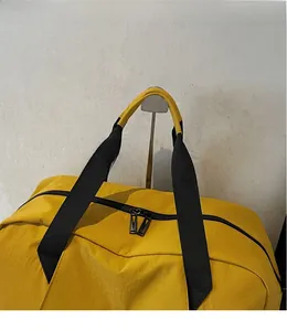 Detail of yellow gym bag with durable black straps and smooth metal zippers