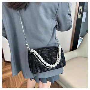 Detail of black rhinestone Boston bag with silver chain and white pearl strap handle