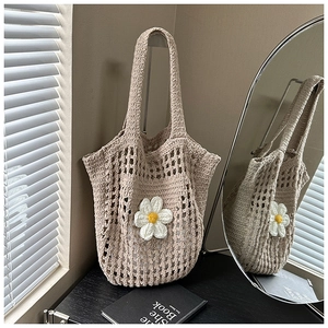 Détail d'un sac cabas en maille tissée avec marguerite au crochet et texture estivale unique