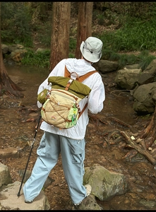 Outdoor hiking backpack in olive green and beige with bungee system and roll-top design