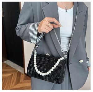 Close-up of black rhinestone Boston bag with pearl chain handle and silver strap