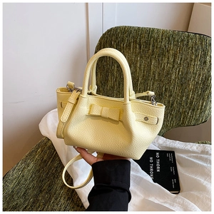 Dettaglio della mini borsa a secchiello giallo chiaro con grana litchi e fiocco