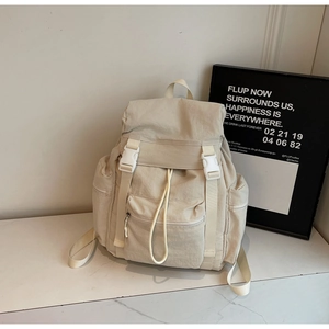 Détail du sac à dos de voyage en nylon beige avec fermeture à boucle et cordon