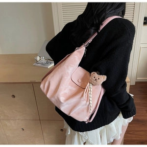 Detailed shot of pink hobo bag with magnetic closure and cute brown bear charm