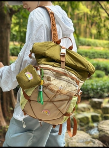 Detail of multi-pocket outdoor backpack featuring mesh pocket and orange compression straps