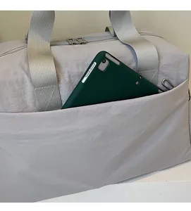 Détail de la poche latérale zippée invisible sur un sac fourre-tout en toile grise