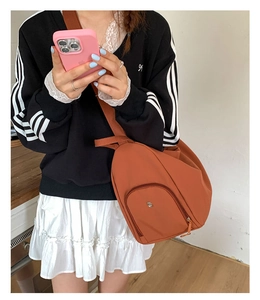 Detail of orange nylon multi-functional crossbody bag with adjustable wide strap and front pocket