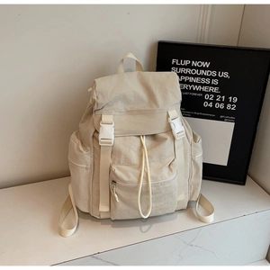 Détail du sac à dos de voyage en nylon beige avec boucle blanche et fermeture à cordon