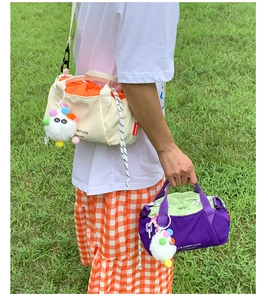 Outdoor shot of minimalist drawstring canvas bags with colorful liners and pompom charms