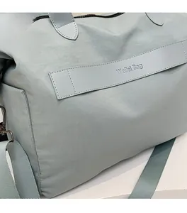 Detail der hellgrünen Nylon-Tragetasche mit gewebten Trägern und Markenetikett