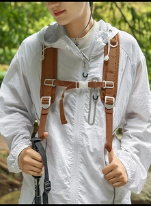 Close-up of a white outdoor backpack with grey drawstring and white plastic buckles