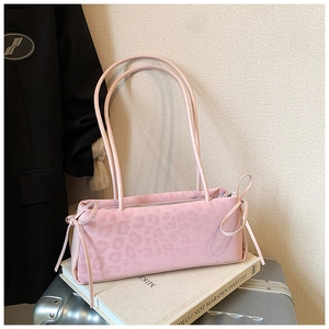 Detail of pink leopard print shoulder bag with bow accents and matte velvet texture