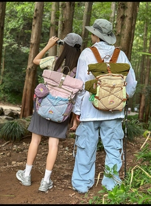 Detail view of water-resistant roll-top outdoor backpack with elastic bungee cords and side pockets