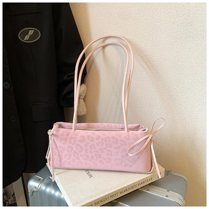 Detail of pink leopard print shoulder bag featuring a side bow and nylon texture