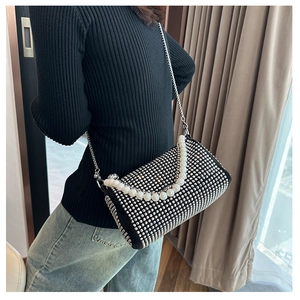 Detail of black Boston bag with sparkling rhinestones and elegant pearl chain handle