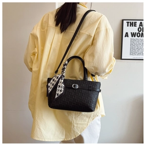 Détail du sac seau noir avec gaufrage en damier et foulard décoratif en pied-de-poule