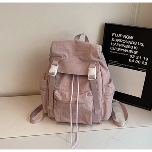Détail du sac à dos en nylon rose imperméable avec boucles blanches et cordon de serrage