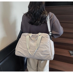 Détail du sac cabas en toile texturée gris-mauve avec bandoulière et doubles poignées