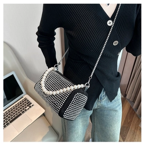 Detail of a sparkling rhinestone Boston bag featuring pearl handle and silver chain strap