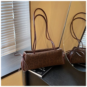 Detail of leopard print suede handbag with drawstring knots and silver zipper closure