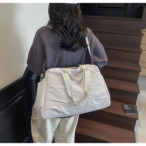Détail d'un sac cabas léger en nylon blanc cassé avec bandoulière réglable