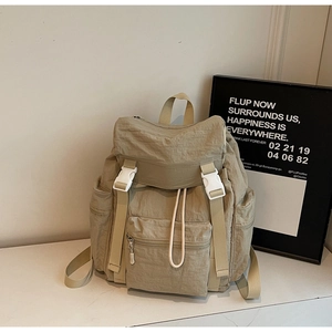 Détail du sac à dos de voyage kaki avec boucle blanche et tissu texturé imperméable
