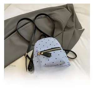 Detail of blue striped mini backpack with heart print on casual suit background