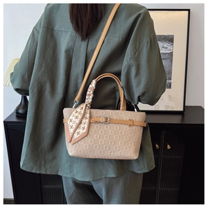 Détail du sac cabas en cuir beige texturé avec boucle et foulard en soie pied-de-poule