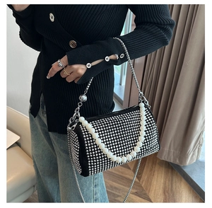 Detail of black Boston bag with sparkling rhinestones and elegant large pearl handle