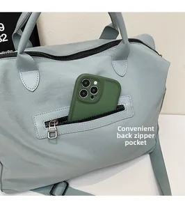 Detailansicht der Reißverschlusstasche an hellblauer Nylontasche mit eingelegtem Handy