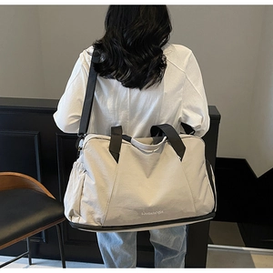 Detailed back view of a beige travel bag with shoe compartment and black straps