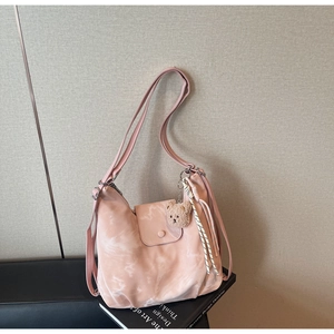 Detail of pink marble pattern tote bag with plush bear charm and snap closure