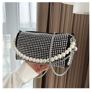 Macro shot of silver rhinestones and large pearl handle on a luxury Boston bag