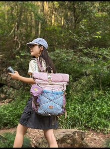 Detail view of RGYI outdoor backpack with roll-top closure and bungee cord in nature set
