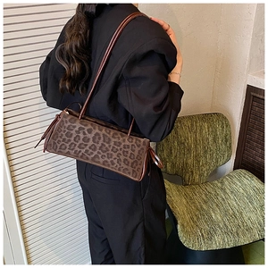 Classic leopard print shoulder bag worn by model in a stylish minimalist setting