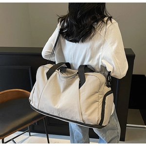 Detail showing the large capacity beige travel bag with separate dry-wet zip compartment