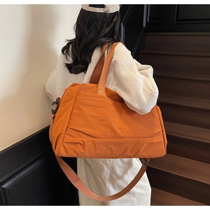Gros plan d'un grand sac de voyage en toile orange avec sangles et poches zippées