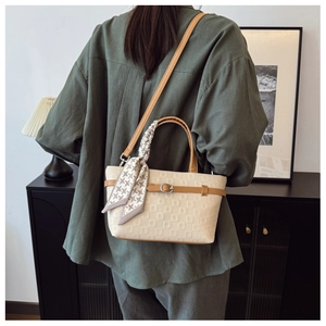 Vue détaillée d'un sac seau matelassé beige avec foulard pied-de-poule et bandoulière