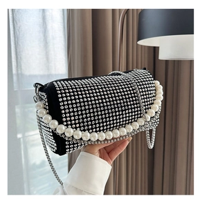 Close-up of black Boston bag with shimmering silver rhinestones and white pearl handle