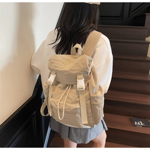 Détail du sac à dos de randonnée beige en nylon imperméable avec cordon et boucle de serrage