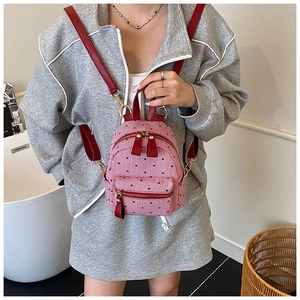Close-up of pink and red mini backpack featuring black heart prints and striped details