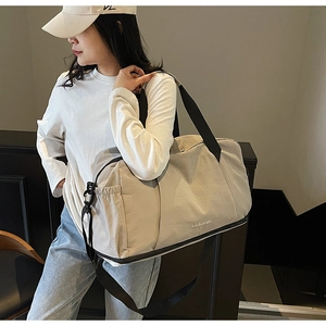 Travel bag with separate shoe compartment shown on female model for travel and gym