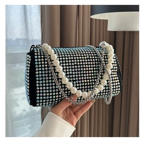 Macro view of black rhinestone Boston bag with pearl handle and silver chain strap