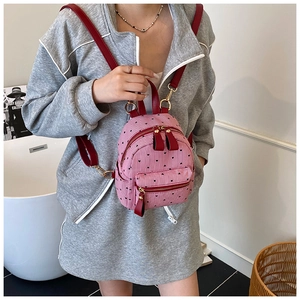 Detail of pink striped mini backpack with black heart prints and gold zipper closure