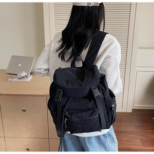 Détail d'un sac à dos en nylon imperméable avec boucles et cordon sur le dos du mannequin