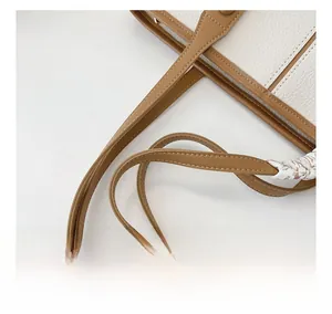 Détail du sac cabas en cuir grainé blanc avec anses marron et foulard élégant décoratif