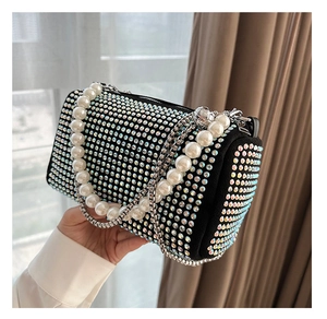 Close-up of black Boston bag with shimmering silver rhinestones and pearl handle strap