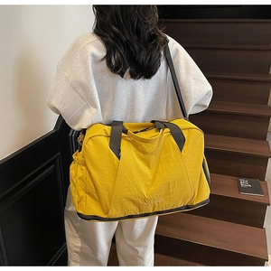 Close-up of a vibrant yellow waterproof fitness bag with shoe compartment on stairs